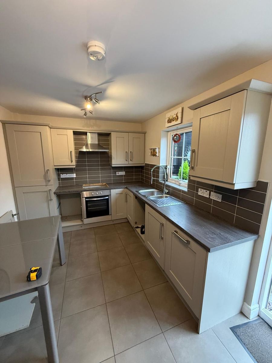 Kitchen with dark wood-effect worktops and a stainless steel sink